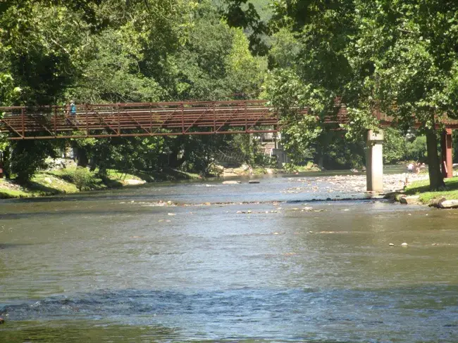 A pedestrian bridge crosses the Oconaluftee River in Cherokee, North Carolina.